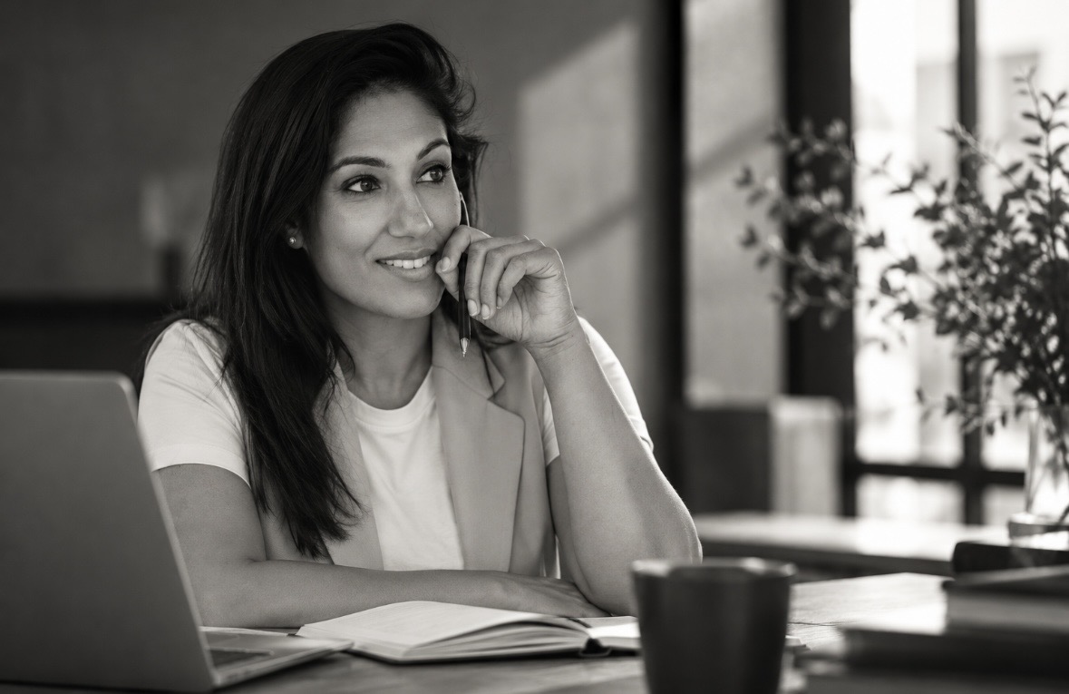 Anisha Biharie glimlachend aan tafel bij het raam